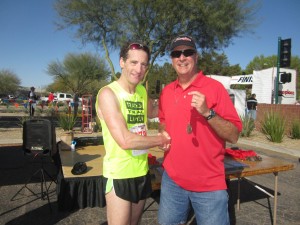 Double Down Race Directors presented Herndon Injury Lawyer Doug Landau with his medal after he completed the Runners Den 5km and 10km races in Phoenix, Arizona before the Association fort Justice CLE sessions resumed