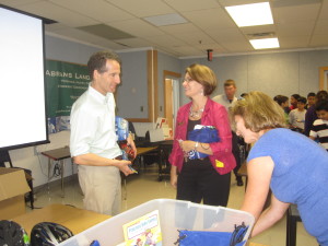 Preparing to give local students free bicycle helmets, lawyer Doug Landau talks with Herndon Virginia Mayor Merkel and Melissa Landau of ABRAMS LANDAU, Ltd.