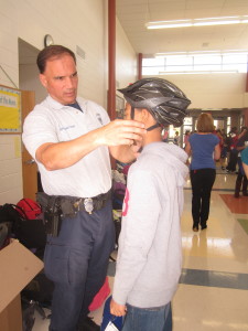 Police officers helped fit Herndon sixth graders with new bike helmets to help prevent brain injury