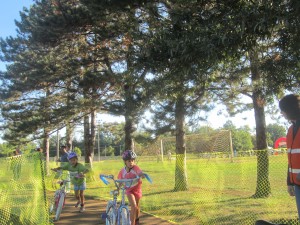 Tiny triathletes stream in with streamers at the Herndon Virginia Kids Triathlon; after dismounting their bicycles safely and removing their helmets after racking their bikes, they would run out from the Herndon Community Center to the W&OD Trail