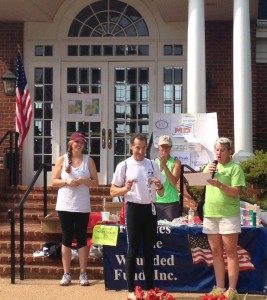 Herndon disability and injury lawyer Doug Landau collects his 2014 Fawn Lake Triathlon overall winner and Wounded Warrior medals after this Spotsylvania Virginia sprint race.