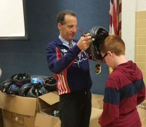 Doug Landau fitting helmet on student