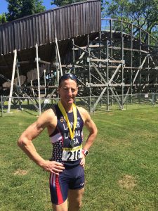 With the Quassey Amusement Park roller coaster behind him, Doug Landau shows his AG runners up medal at the USAT New England DUathlon Championships held in Middlebury, CT at the Pat Griskus races.