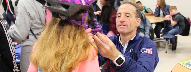 Doug Landau fitting helmet on student