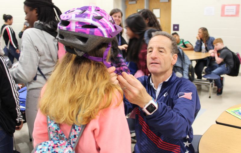 Doug Landau fitting helmet on student