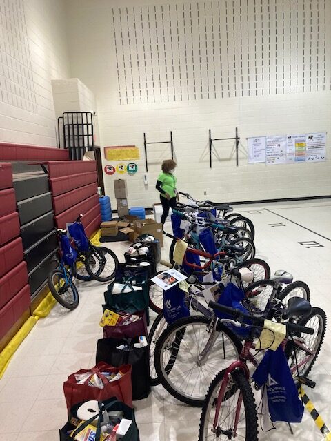 a dozen bicycles with bags of donated food, in gymnasium at Potowmack Elementary School.