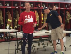 Even a small check helps. Here Social Security disability lawyer Doug Landau holds his medal & check from the Vincentown, New Jersey Triathlon