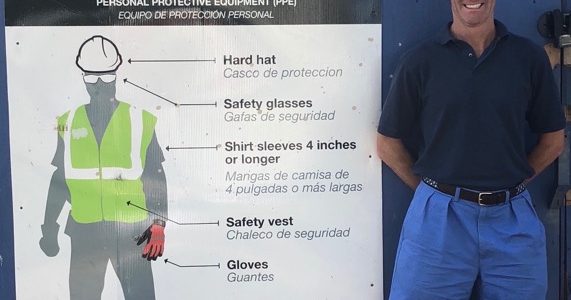 attorney doug landau next to a jobsite dress code sign