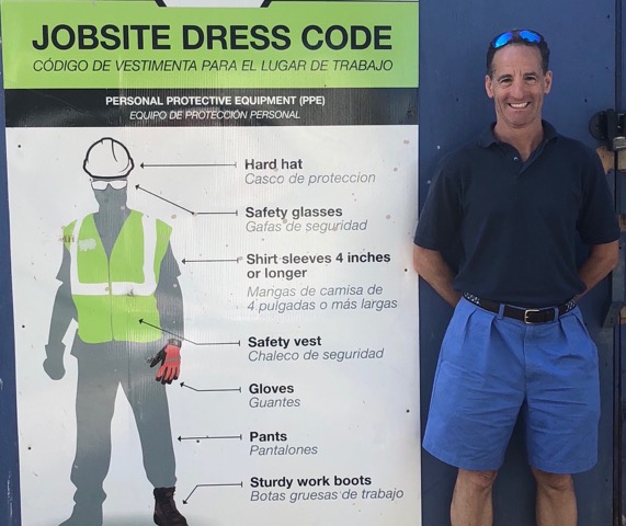 attorney doug landau next to a jobsite dress code sign