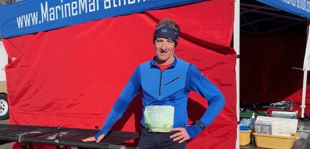 Attorney Doug Landau poses in front of a medical tent at the Marine Corps Marathon