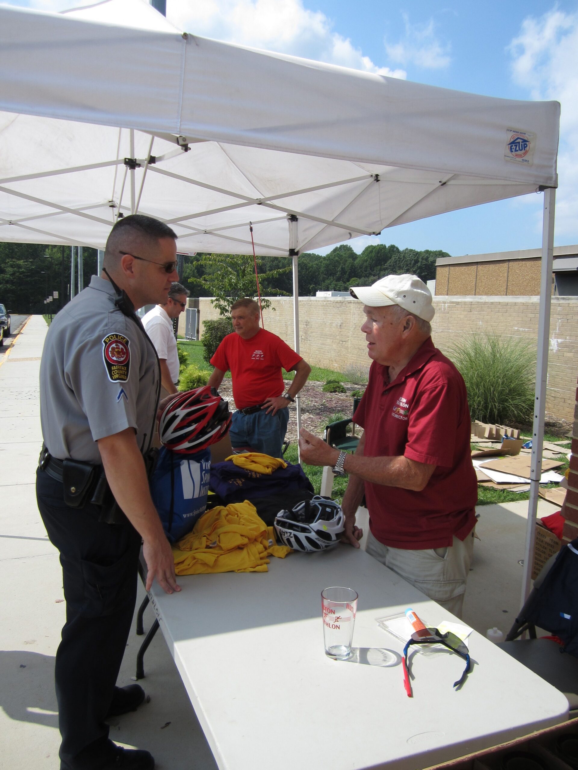 Even Fairfax County Police submit their bike helmets for safety inspection by race volunteers before the Annual Reston Triathlon