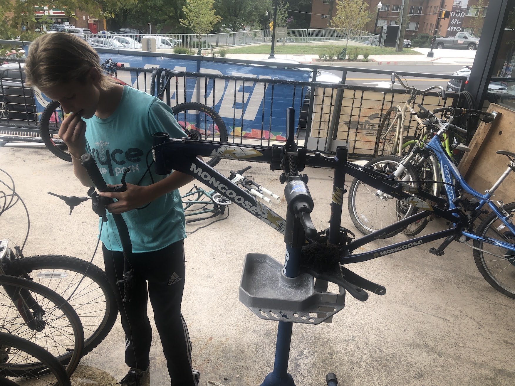 Aelin, young mechanic in Earn-a-Bike program for Phoenix Bikes, stripping bikes of parts