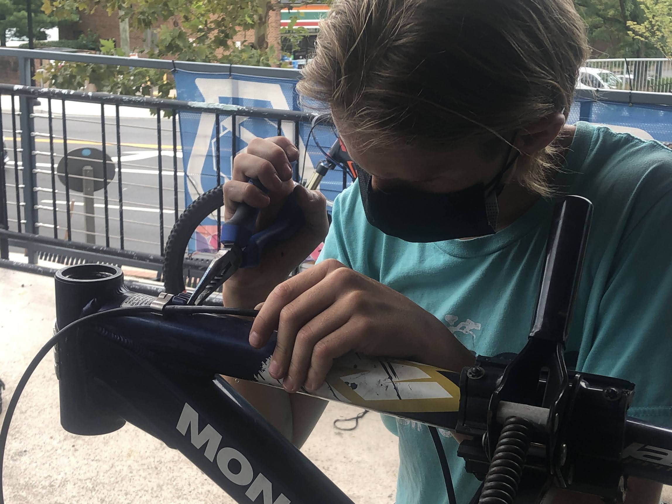 Aelin, young mechanic in Earn-a-Bike program for Phoenix Bikes, stripping bikes of parts