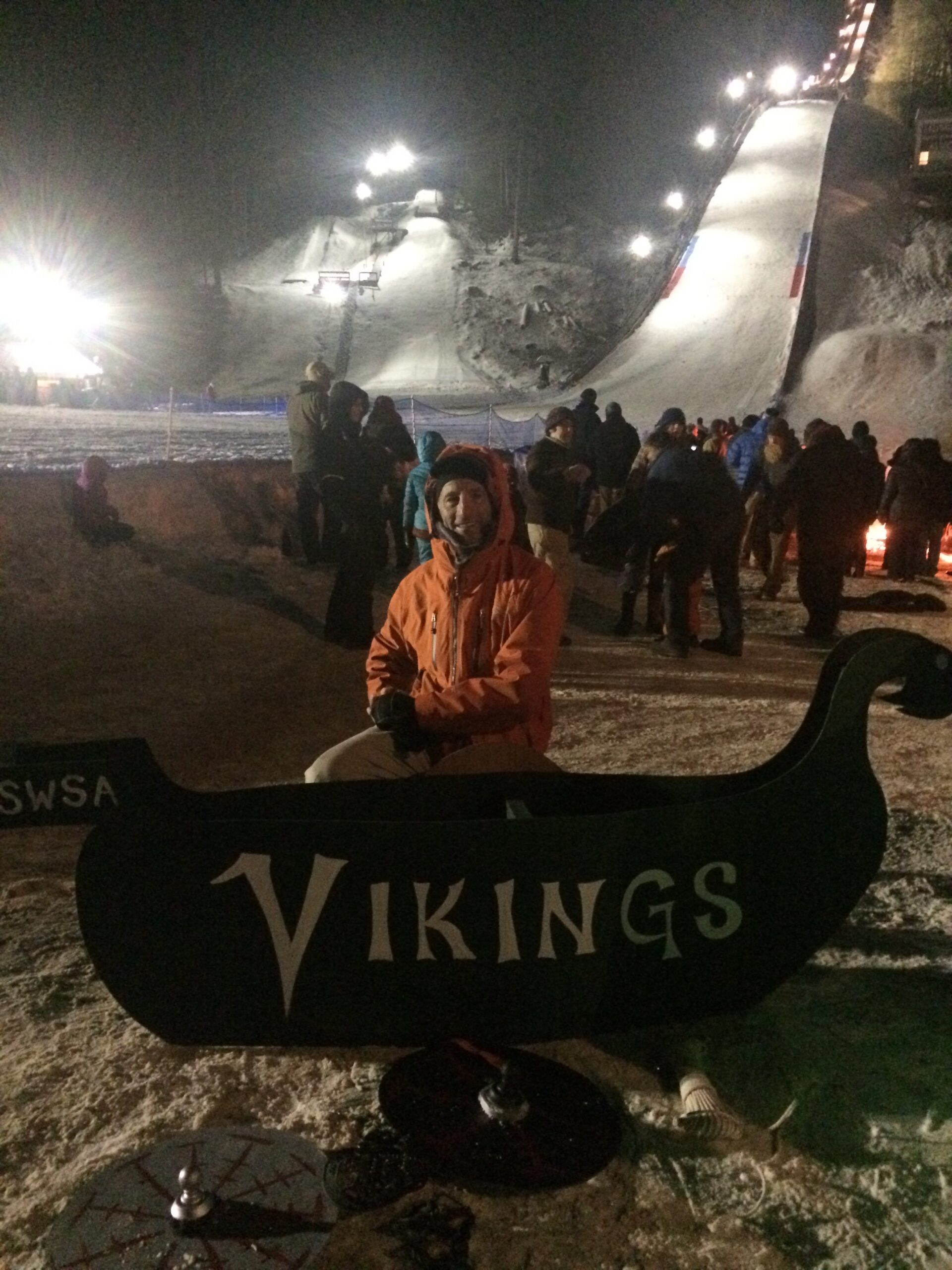 Doug Landau & the sled of the winning Vikings team, with the SWSA Ski Jump hills in the background